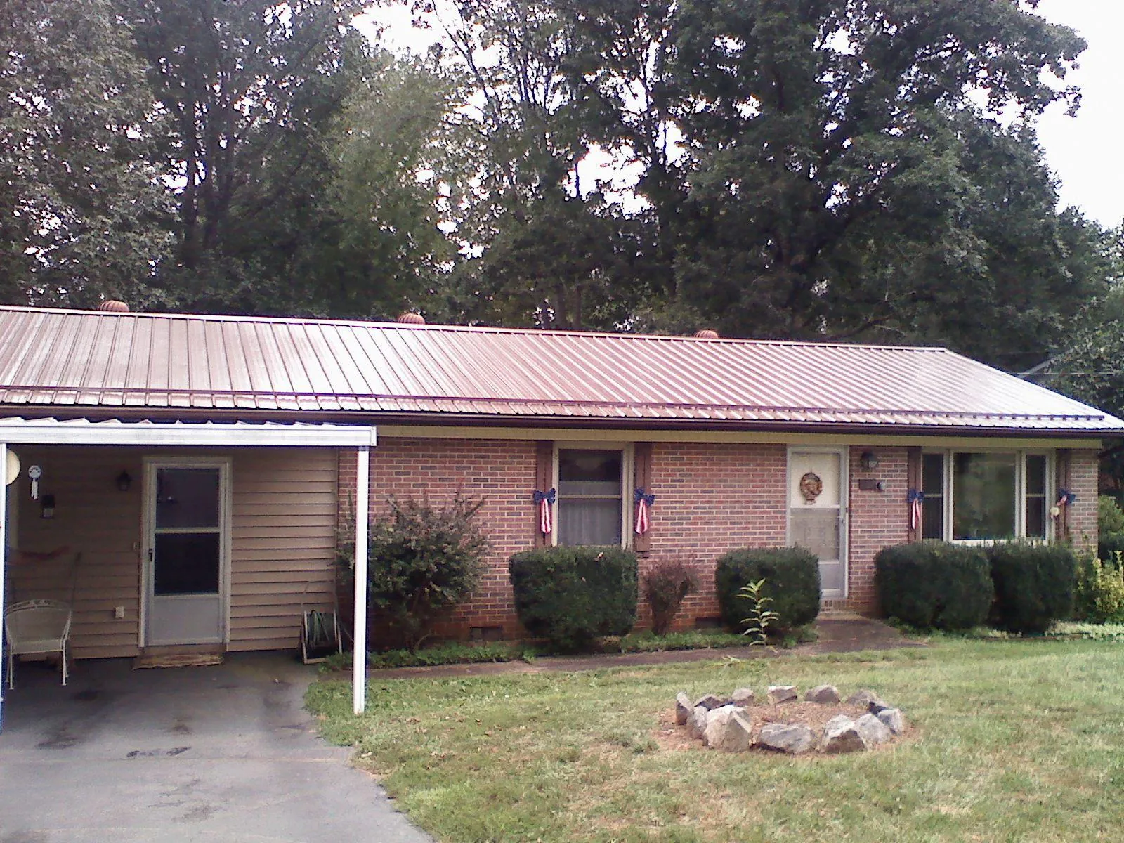 Bronze metal roof and carport on a brick ranch home — Roof Repair work by our crew in Colusa
